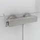 Brausearmatur in Silber mit zwei runden Bedienelementen und einem einzelnen Auslauf, montiert an einer Wand. Produkt von Ideal Standard.